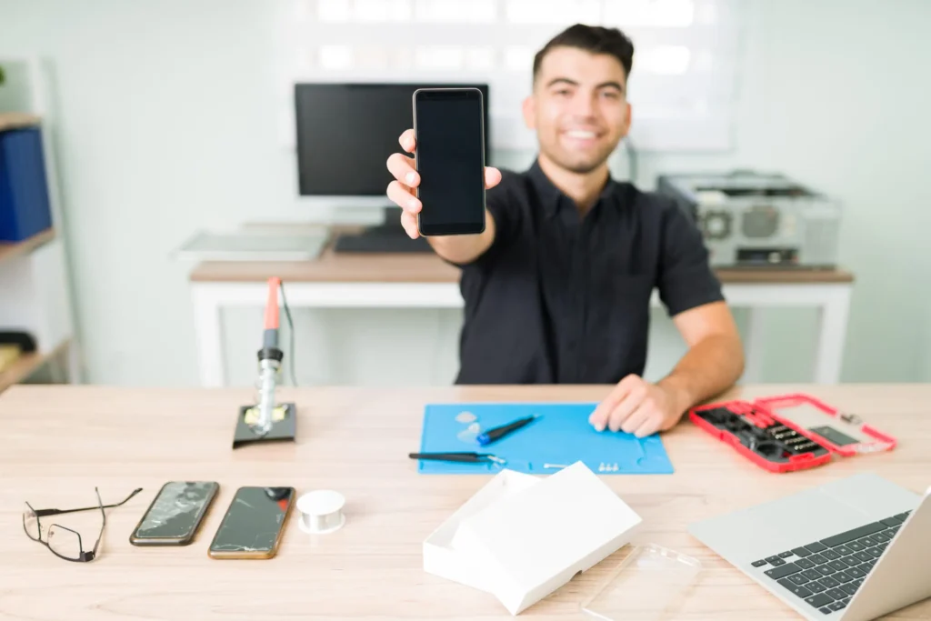 just-as-new-happy-young-man-showing-fixed-smartphone-smiling-technician-repairing-broken-screen-smartphone-1-scaled (1)