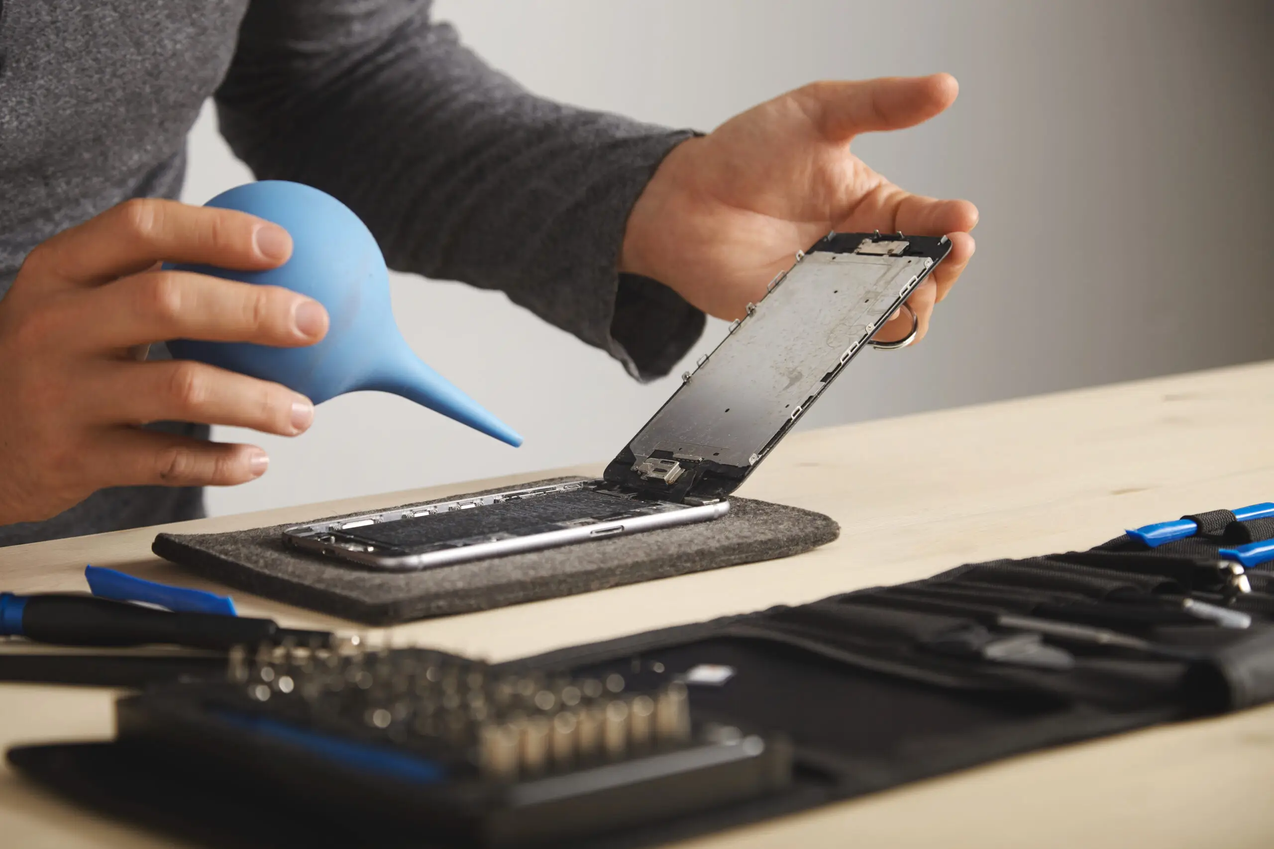 man-is-working-carefully-his-lab-repair-clean-smart-phone-using-syringe-blow-out-all-dust-from-device-1-scaled