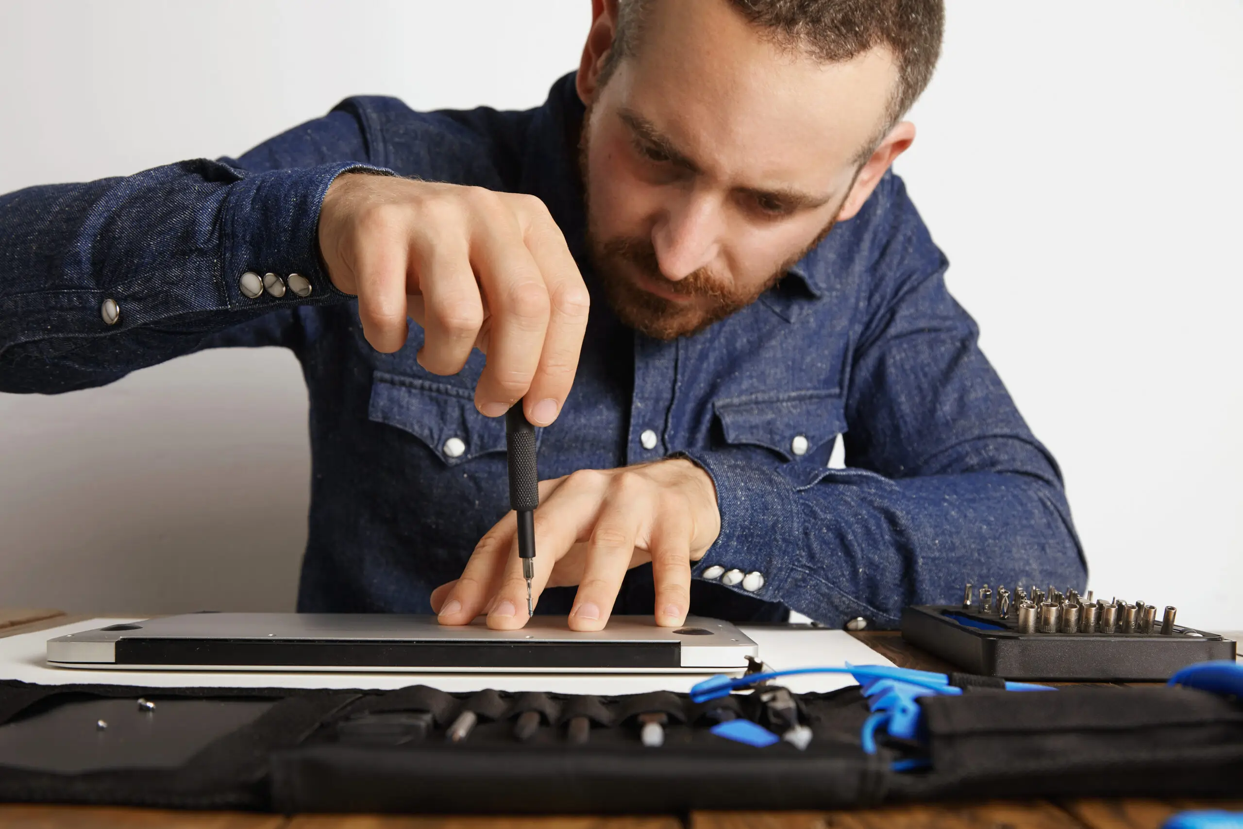 professional-accurately-unscrewing-case-metallic-slim-laptop-his-electric-service-lab-near-tool-bag-clean-repair-it-front-view-1-scaled
