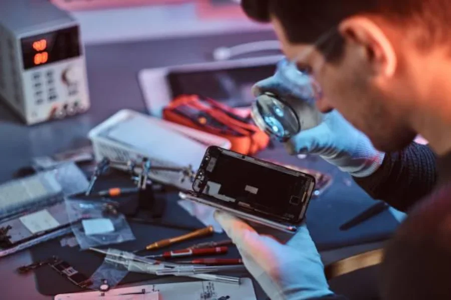 technician-examining-mobile-phone-parts-in-a-workshop